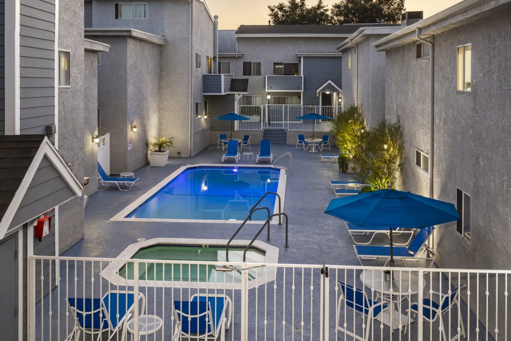 Apartments in Encino An apartment complex in Encino with a swimming pool and lounge chairs.